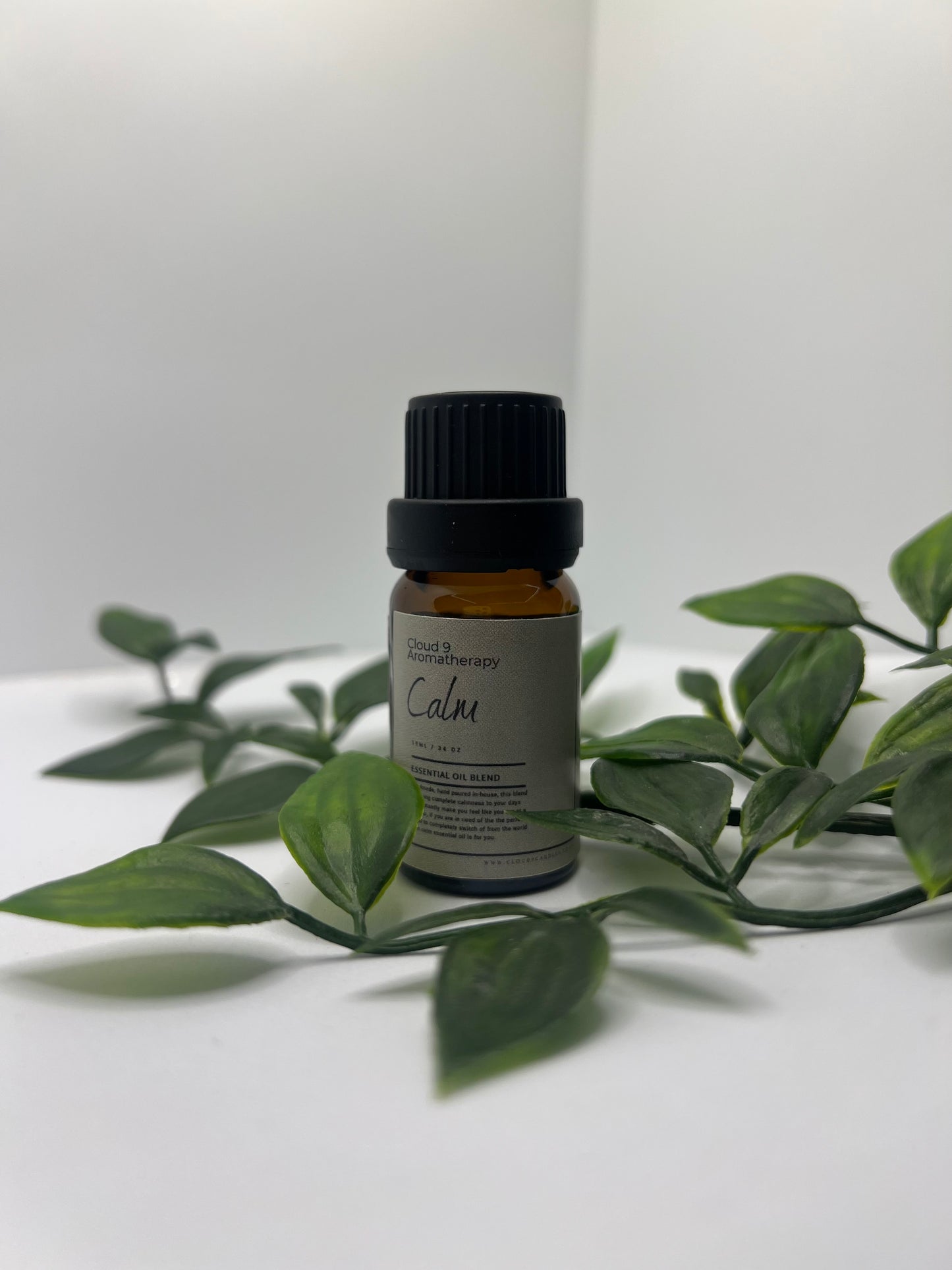 Amber 10 ml essential oil bottle labeled ‘Calm’ with sprigs of lavender and lemongrass, conveying natural relaxation.