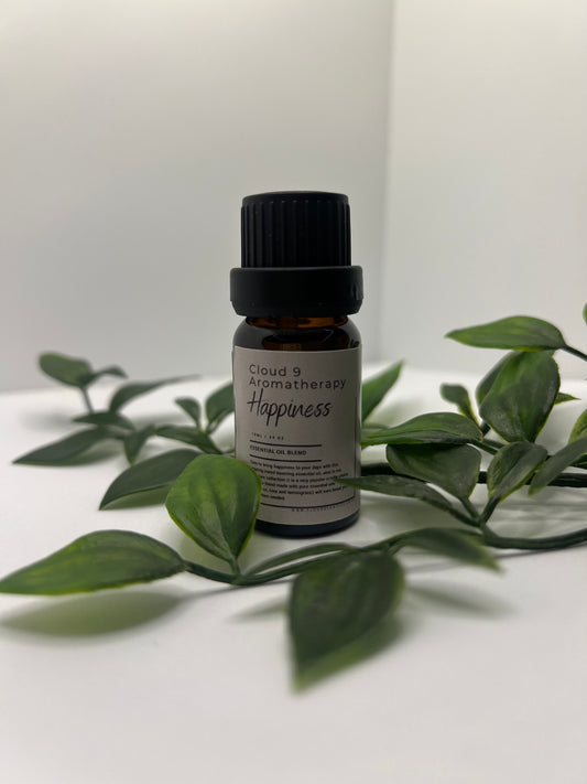 Single amber essential oil bottle standing beside foliage, spotlighting a handcrafted Cloud 9 blend designed for aromatherapy benefits.